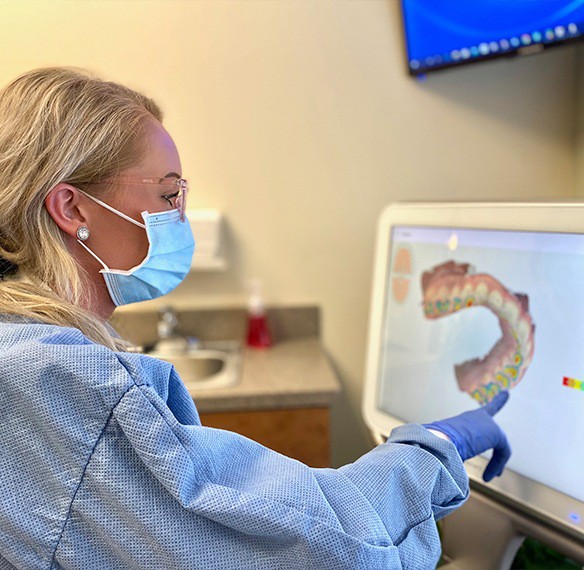 Dental team member looking at impressions on computer