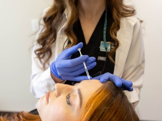 Injecting Botox into patients forehead