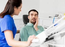 Man talking to dental assistant about dental emergency