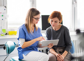 Woman talking to dental assistant about in-house plan 