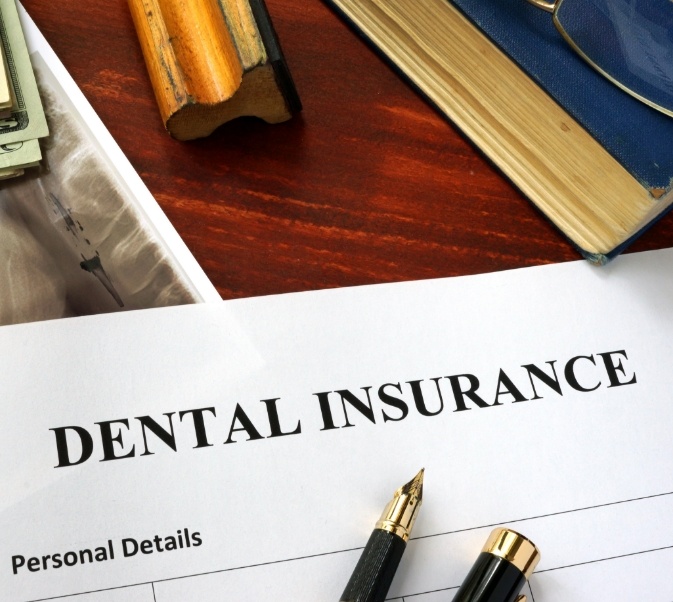 Dental insurance form with pens on top