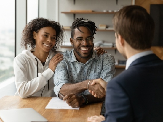 Couple with man shaking suited mans hand
