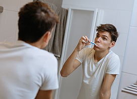 Male college student brushing teeth 