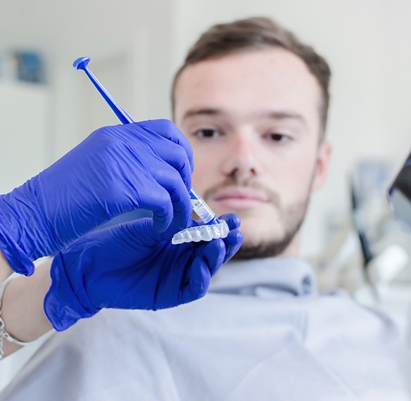 Dentist preparing teeth whitening tray