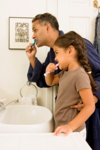 father and daughter brushing teeth with at-home care tips from the family dentist el reno loves