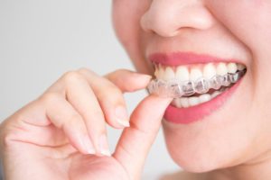 woman putting on Invisalign 