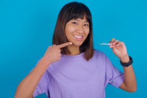 teen girl pointing to Invisalign tray 