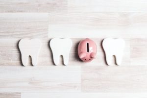 teeth graphics next to piggy bank 