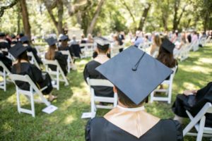 high school students sitting at graduation 