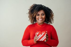 smiling woman holding Christmas present 