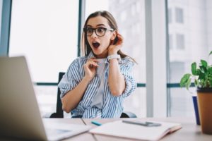 young woman looking surprised at computer 