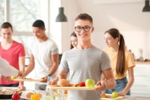 young male student with Invisalign in cafeteria 