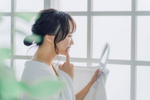 woman looking at gums in the mirror 