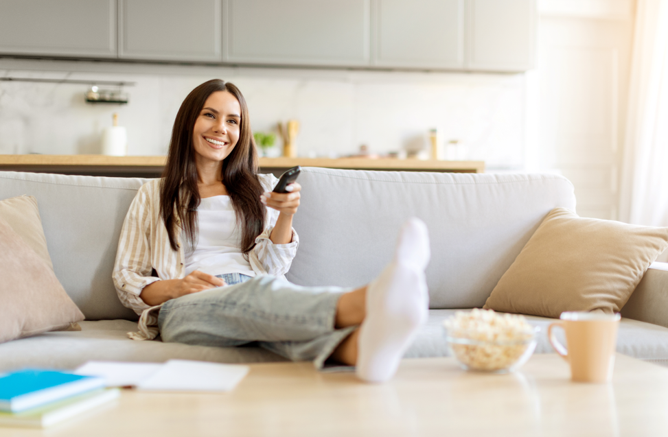 young woman watching TV on couch